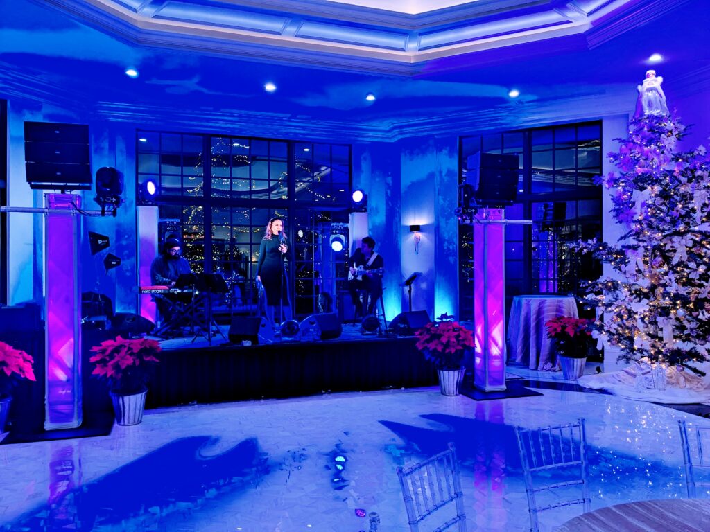 Picture of a singer on a panel stage with blue room uplights, decor lighting