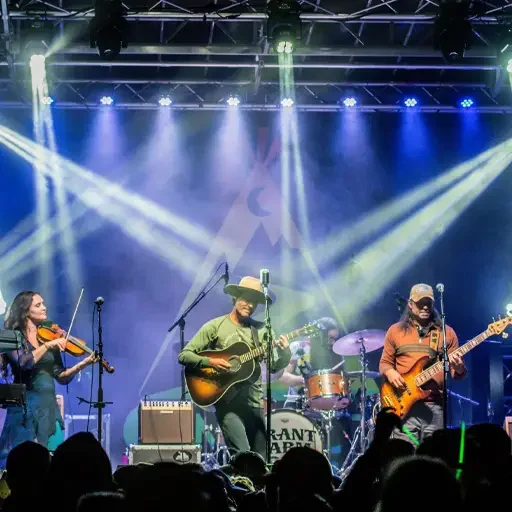 Concert stage lighting with 3 country music performers on stage