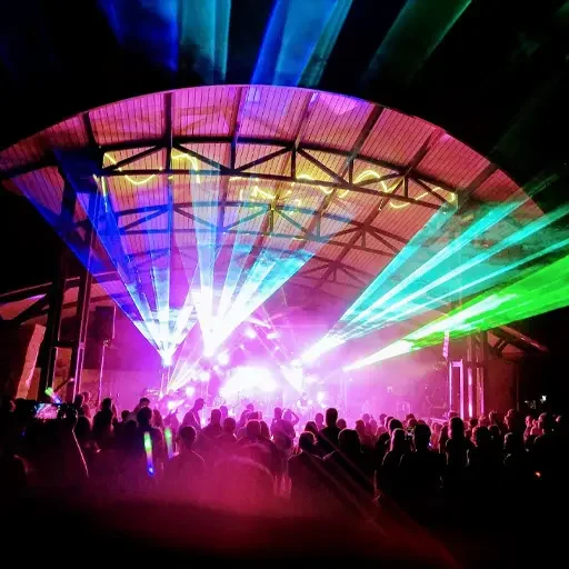 Laser lighting enhanced by fog, full concert stage and spotlights, and architectural lighting. Concert stage lighting with laser lights